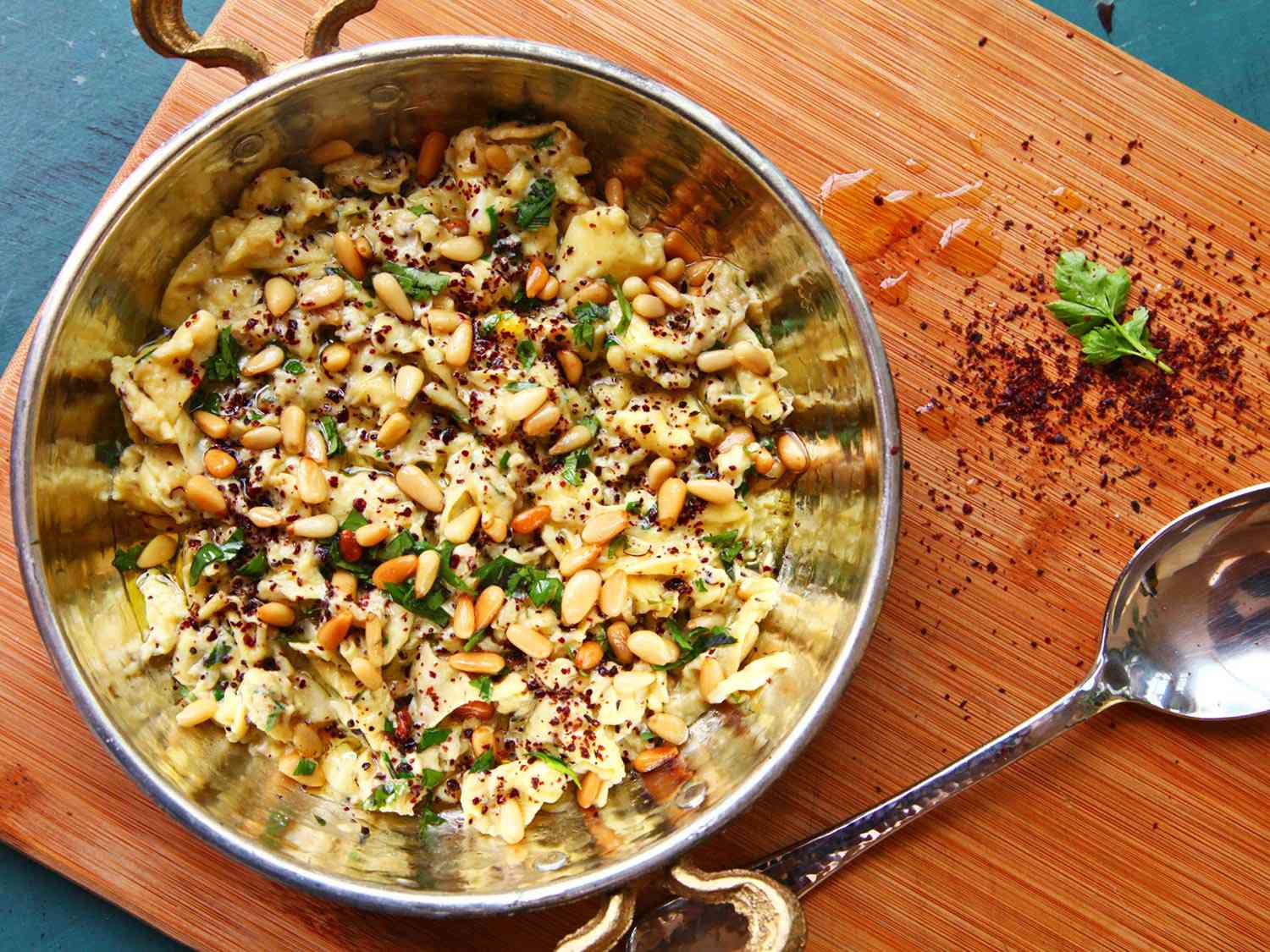 Overhead shot of soft-scrambled eggs topped the eggs with sumac, parsley, pine nuts, and olive oil. 