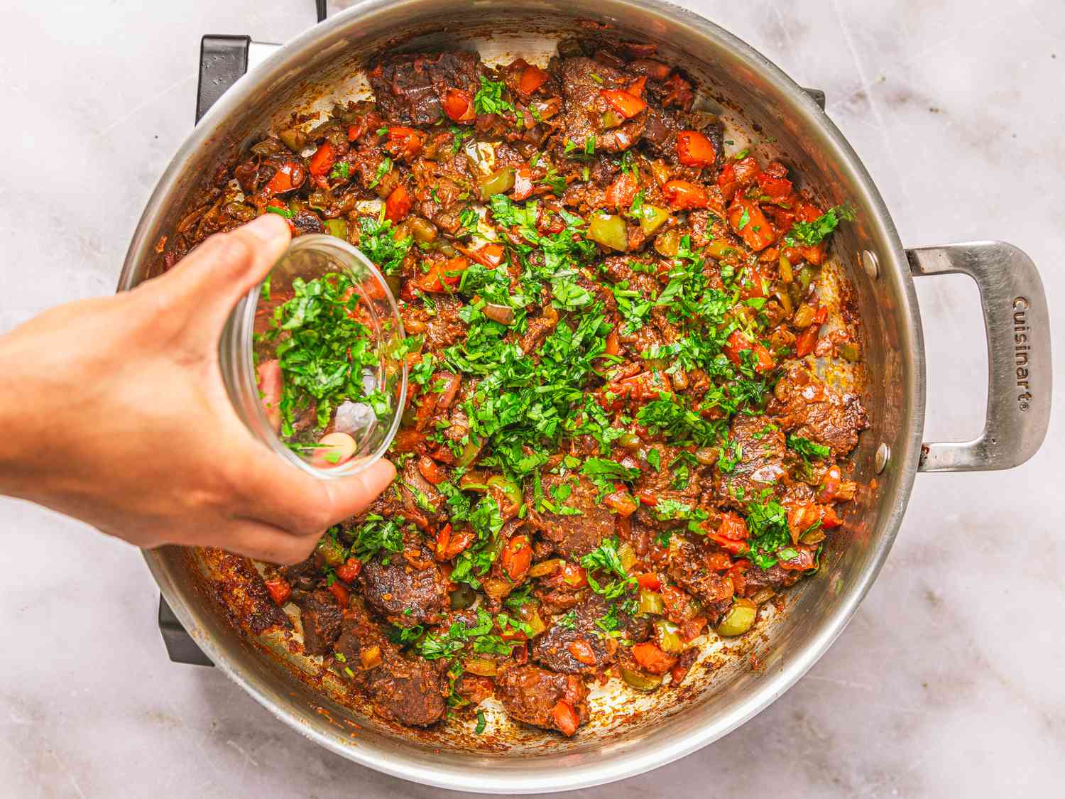 Overhead view of adding herbs into pot