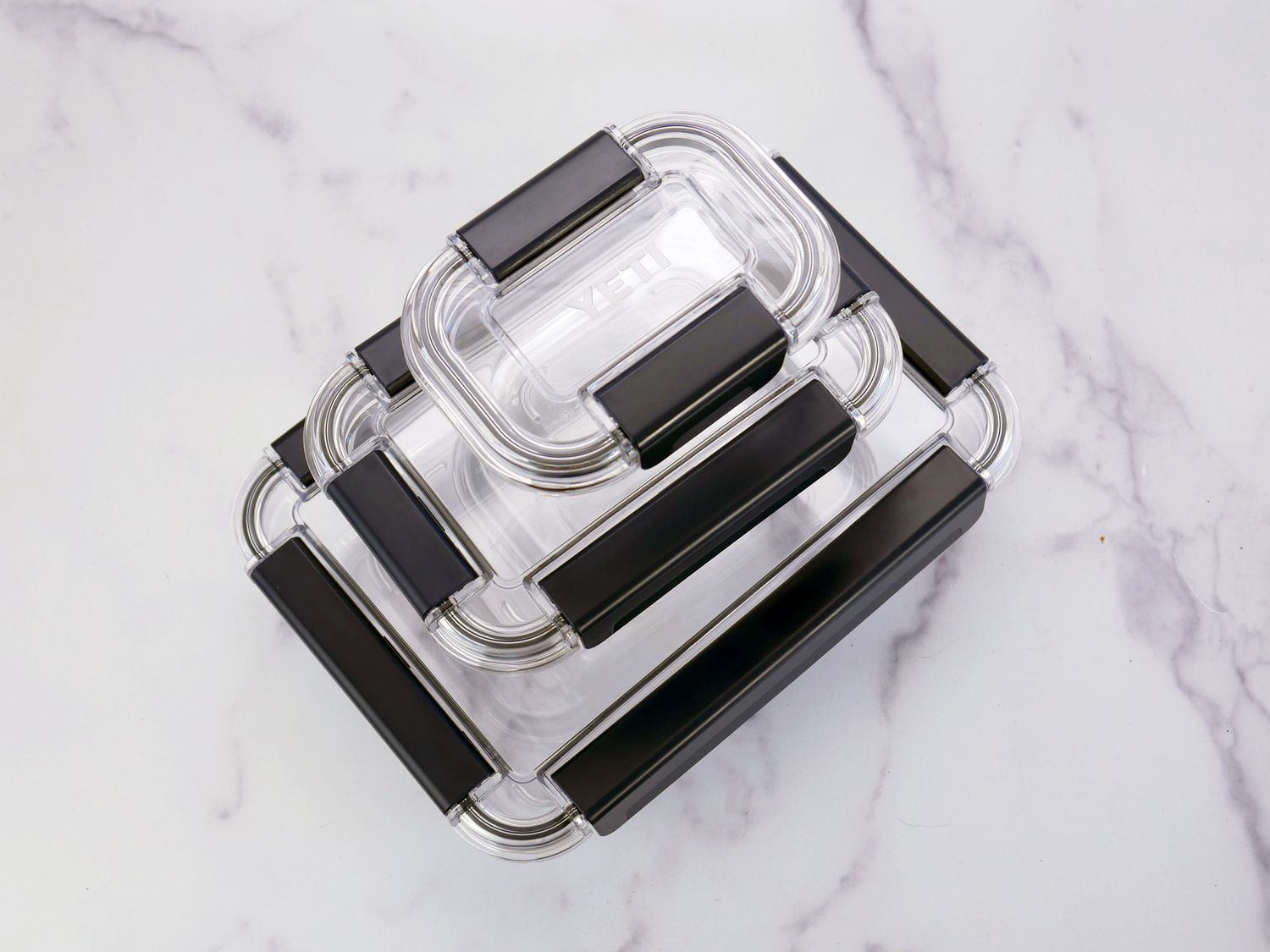 a stack of three yeti food storage containers on a marble surface