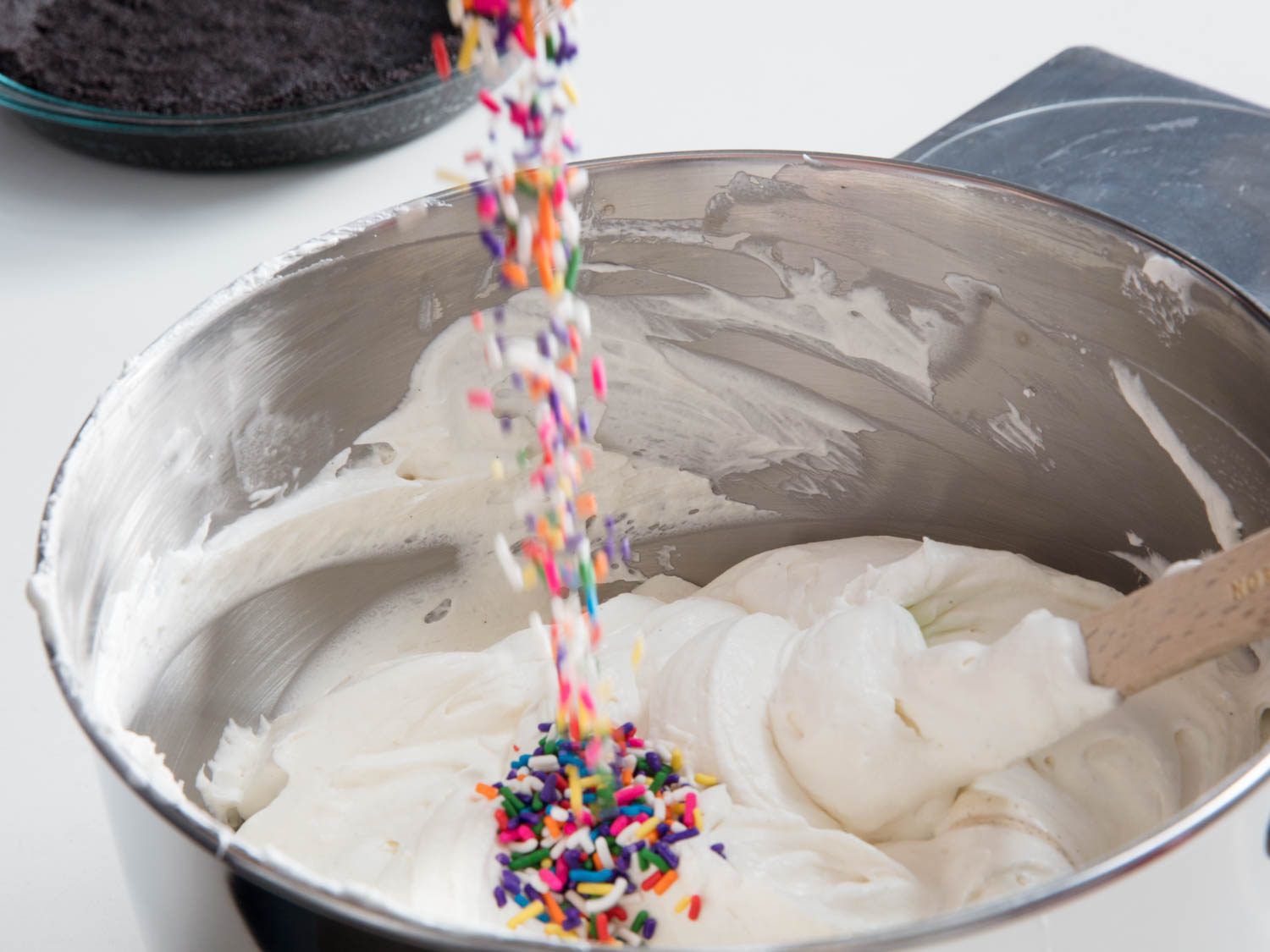 rainbow sprinkles being added to the ice cream