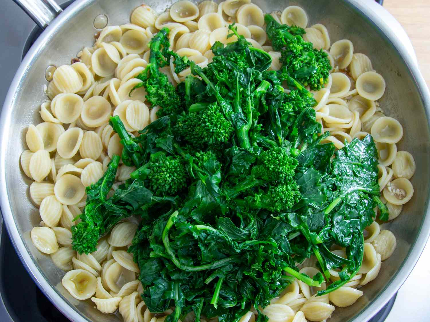Cooked orecchiette and blanch broccoli rabe in a skillet.