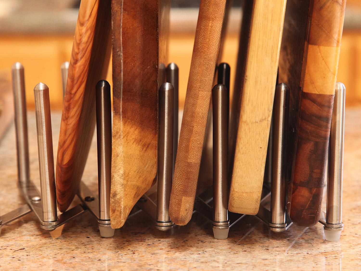 Closeup of oiled cutting boards standing upright in an expandable pot lid rack.