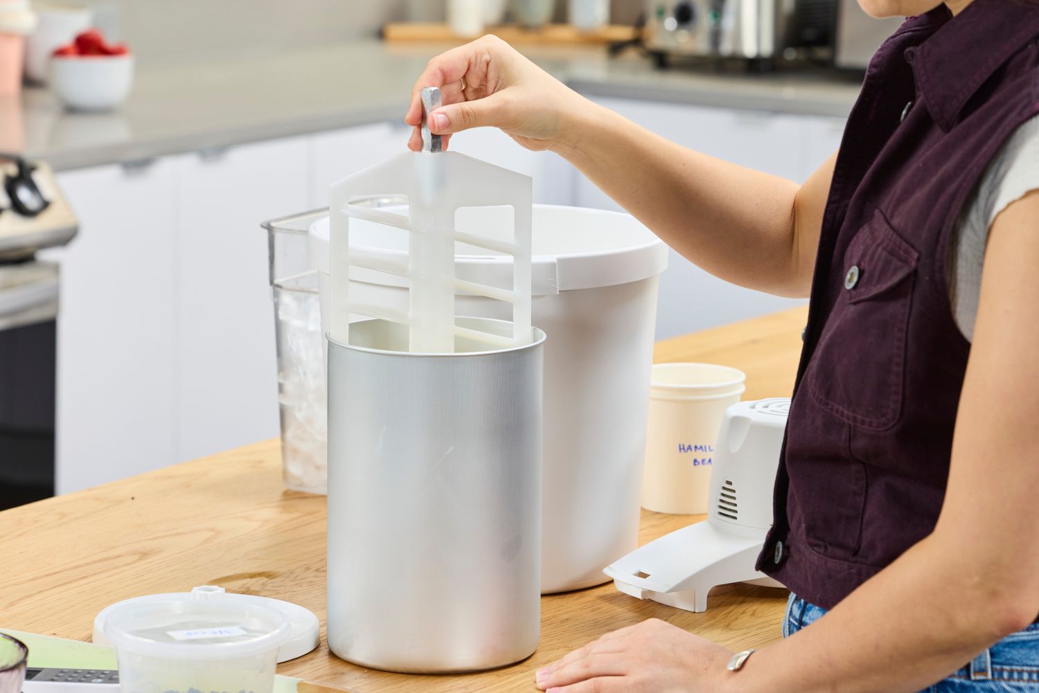 A person assembling the Hamilton Beach Automatic Ice Cream Maker