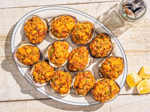 Overhead view of stuffies on a plate with lemon wedges and fork