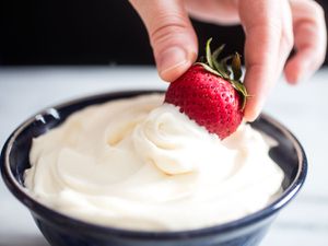 Dipping a strawberry into a bowl of homemade Cool Whip. 