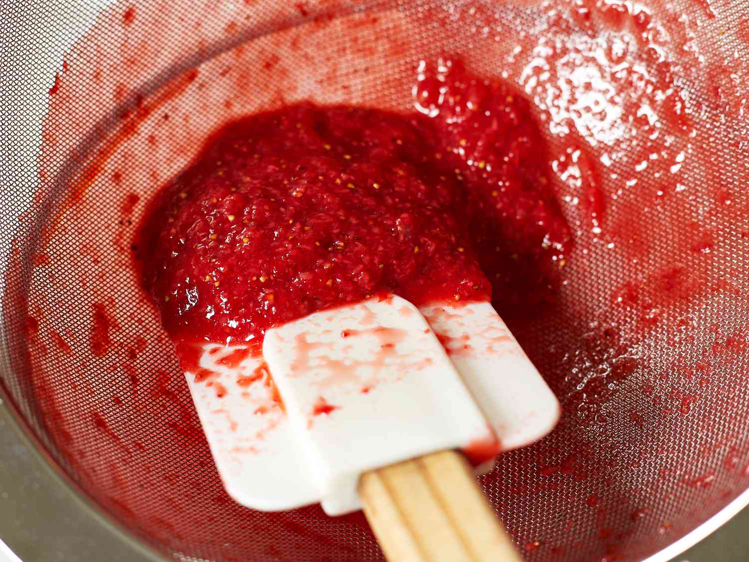 an upvclose look at the seeds left in a strainer after making strawberry sauce