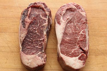 Two steaks side by side, one dry-aged and the other fresh.