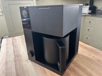 The Fellow Aiden coffee maker on a wooden table in a kitchen.