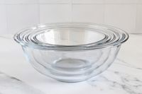 A set of Pyrex nesting glass mixing bowls placed on a marble countertop