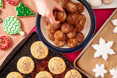 Overhead view of a hand reaching to grab many cookies