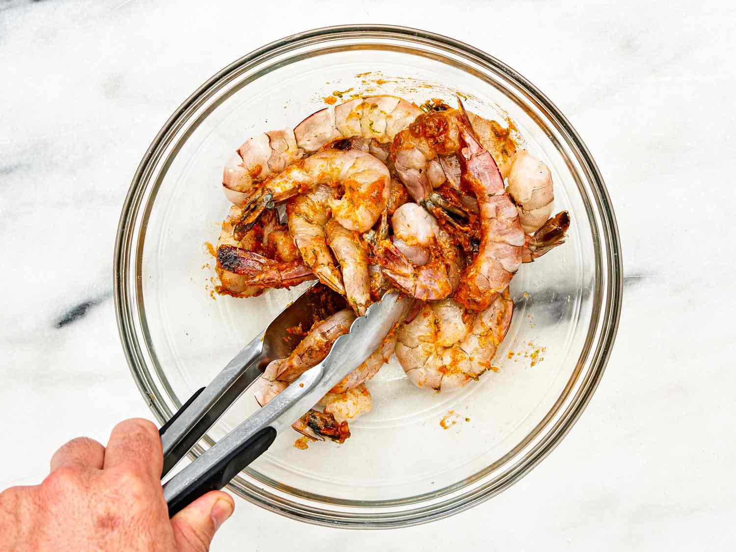 Overhead view of coating shrimp in butter