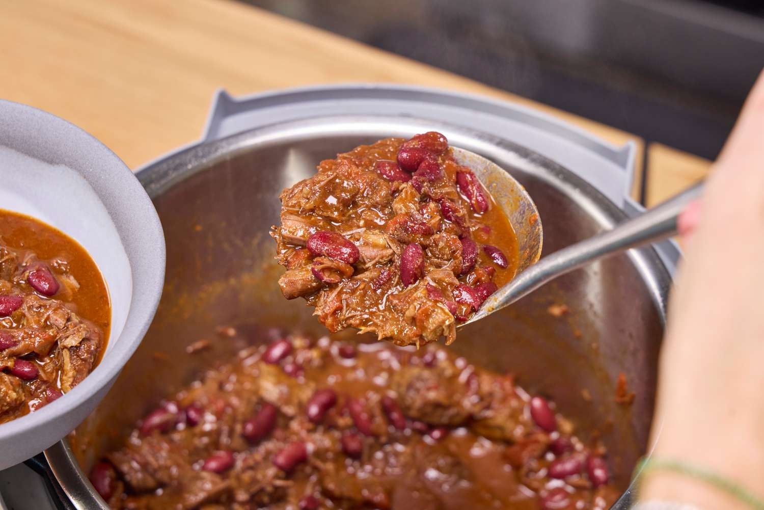 Chili made in the Instant Pot Duo Plus 8 Quart Multi-Use Pressure Cooker is spooned into a bowl