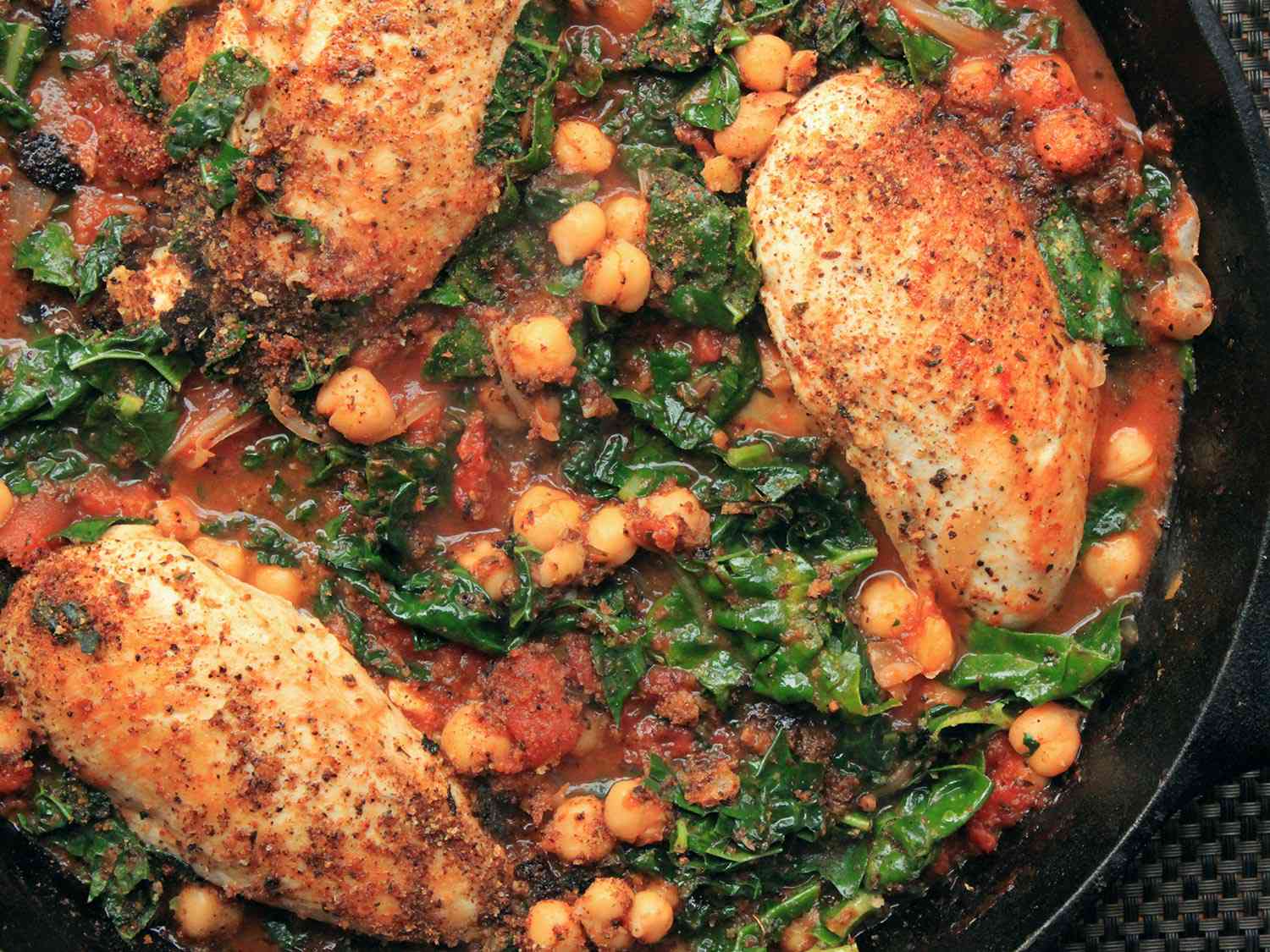 Chicken breasts in tomato sauce with chickpeas and kale.