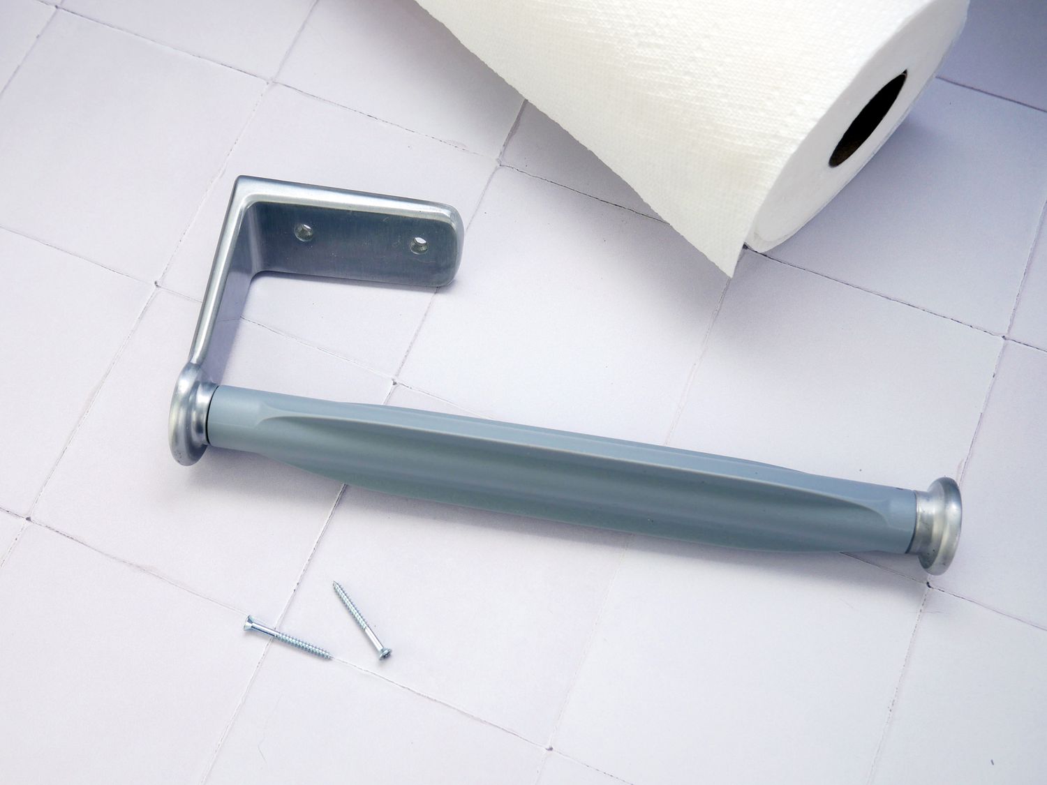 the oxo mounted towel holder with screws and a paper towel on a white tile surface