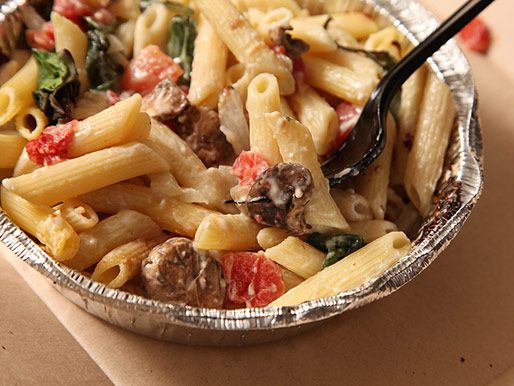 A close up of a Domino's pasta primavera in an aluminum take-out container.
