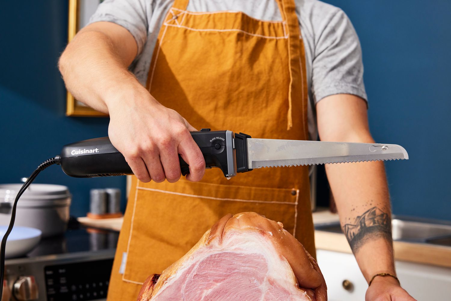 the cuisinart electric knife being held over a ham