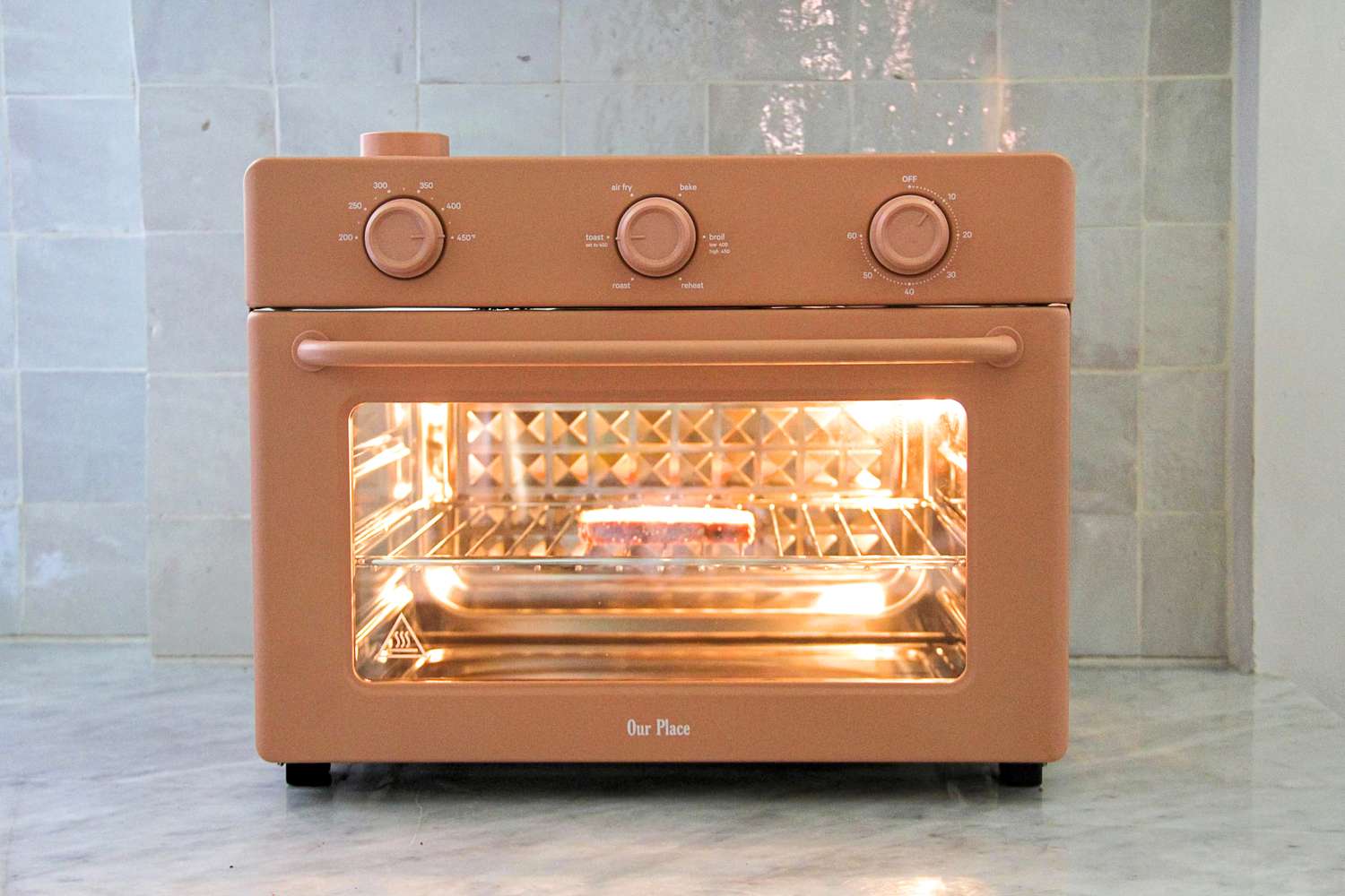 An Our Place Wonder Oven with food cooking inside on a tray