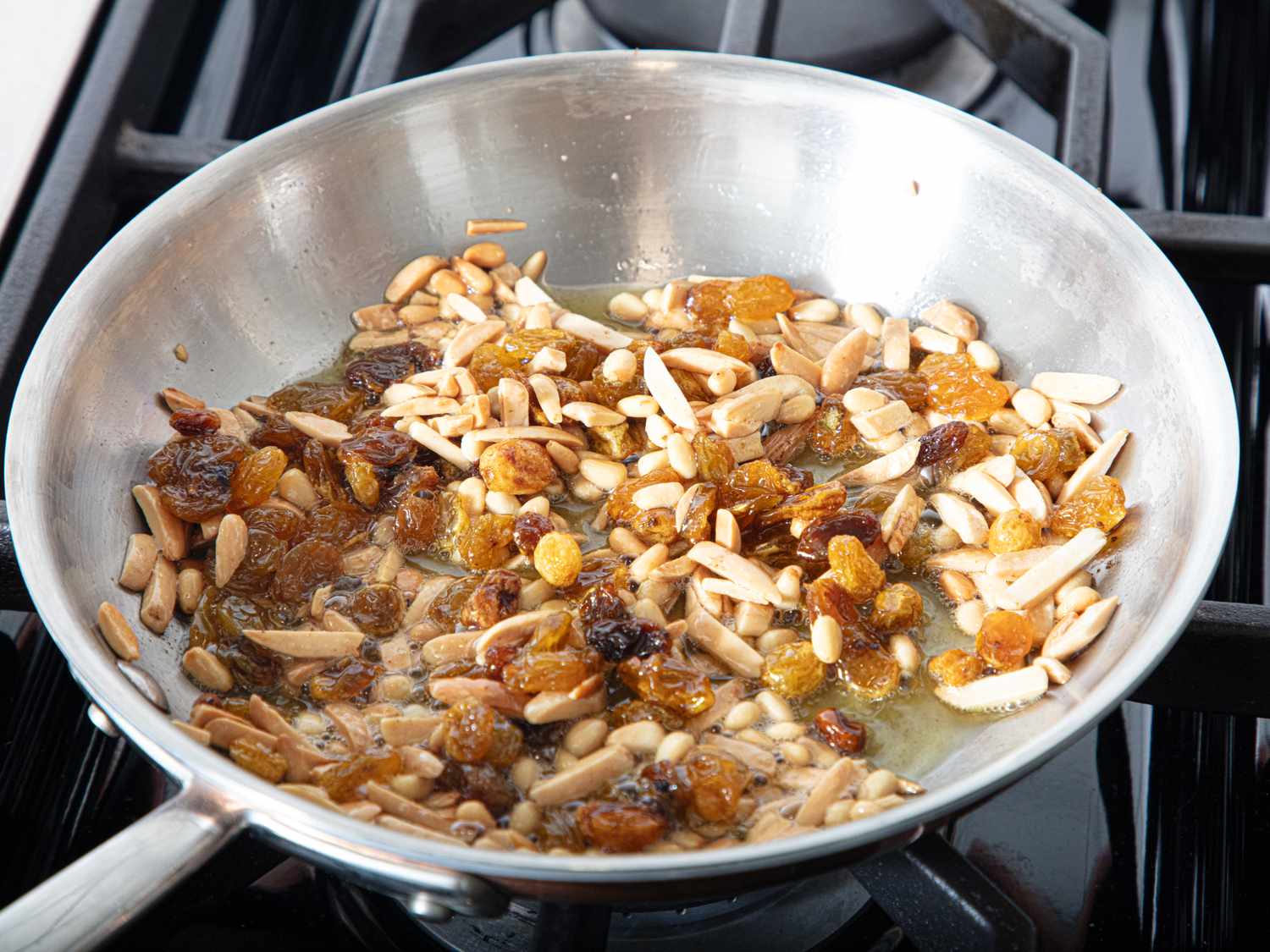Sauting raisins and slivered almonds in a pan