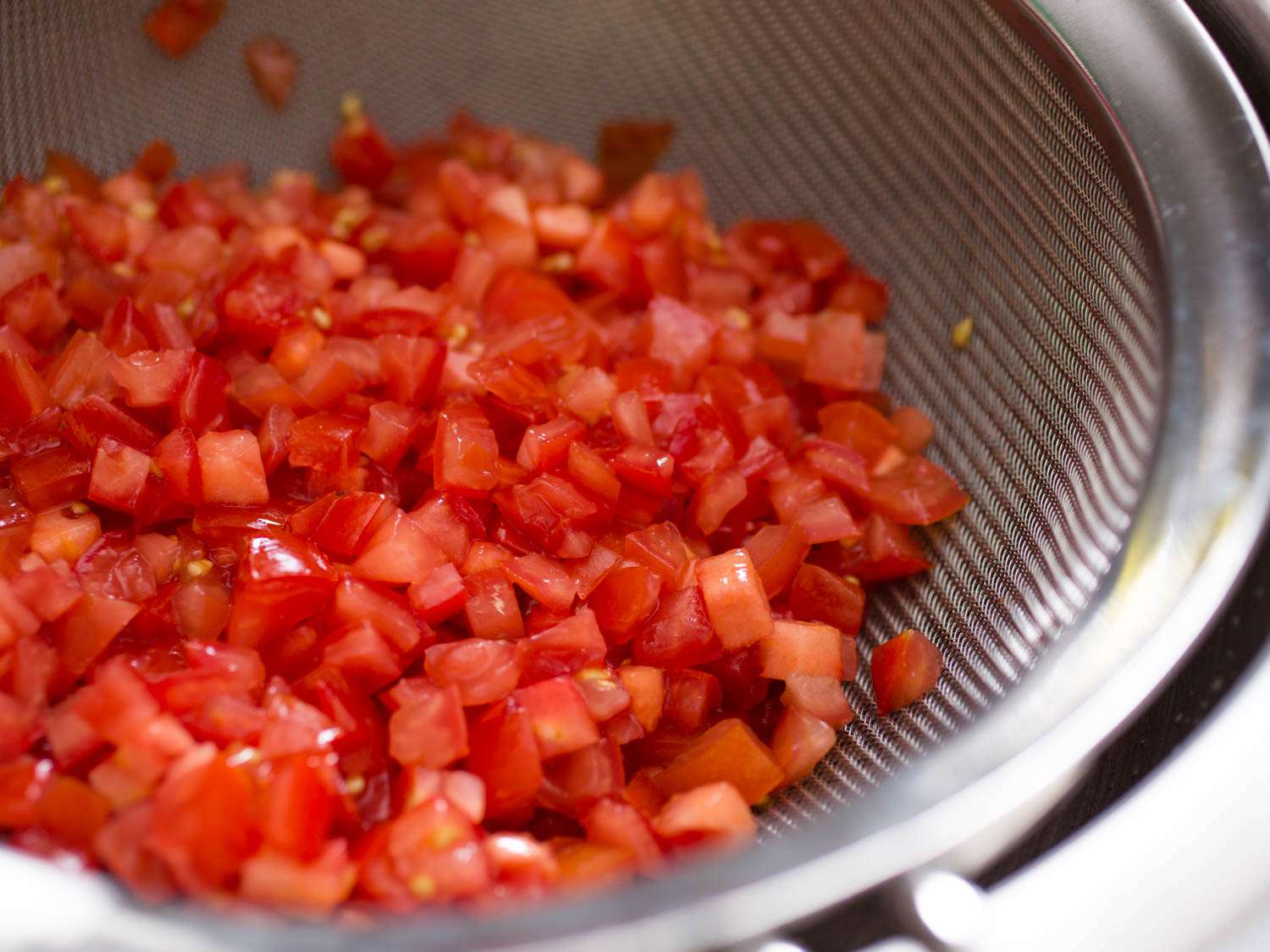 Finely diced tomatoes for tabbouleh in a strainer.