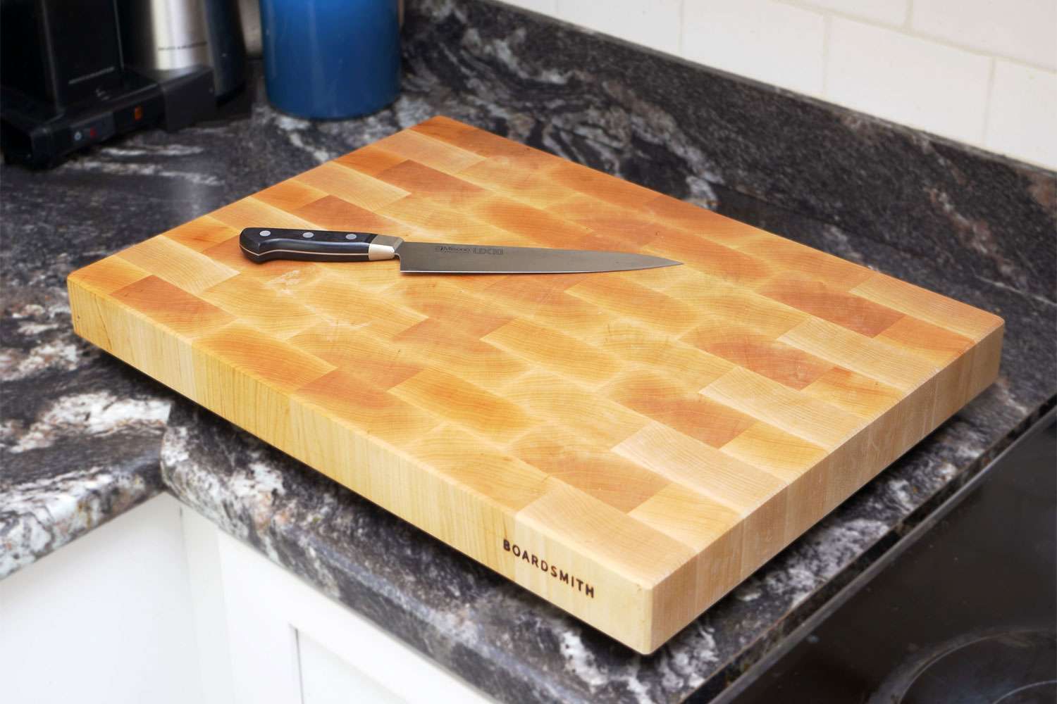 Boardsmith cutting board on a countertop with a chef's knife on the board