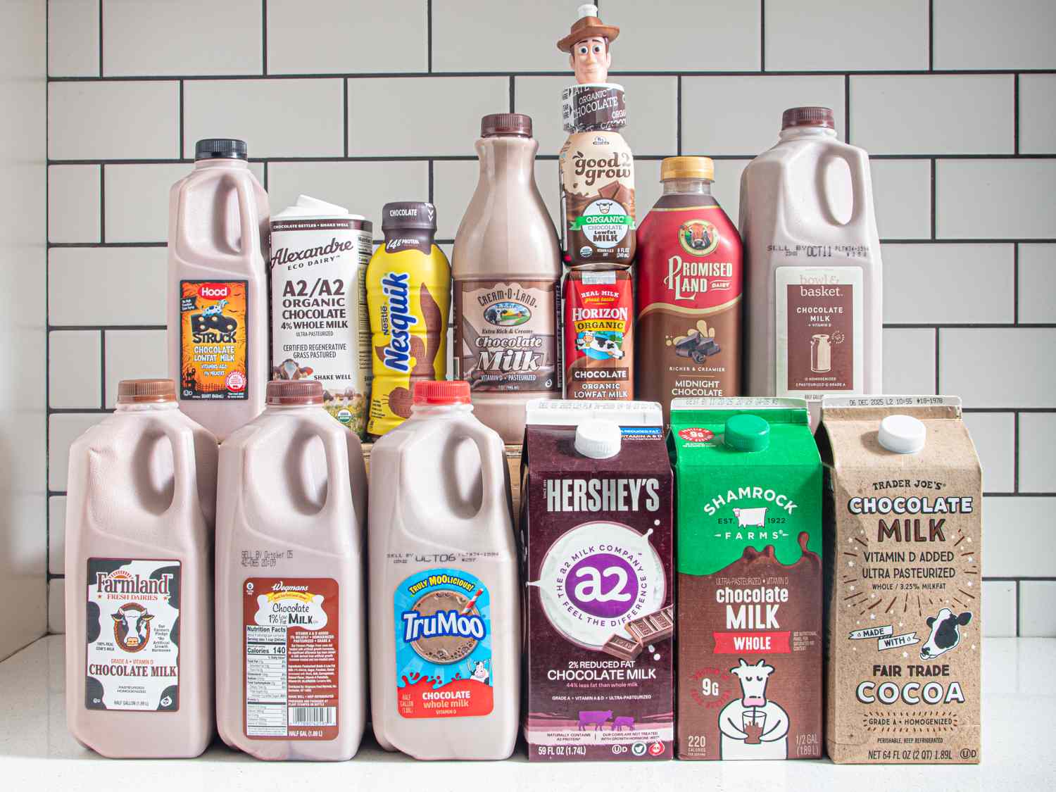 A variety of chocolate milk brands displayed on a counter including cartons and bottles