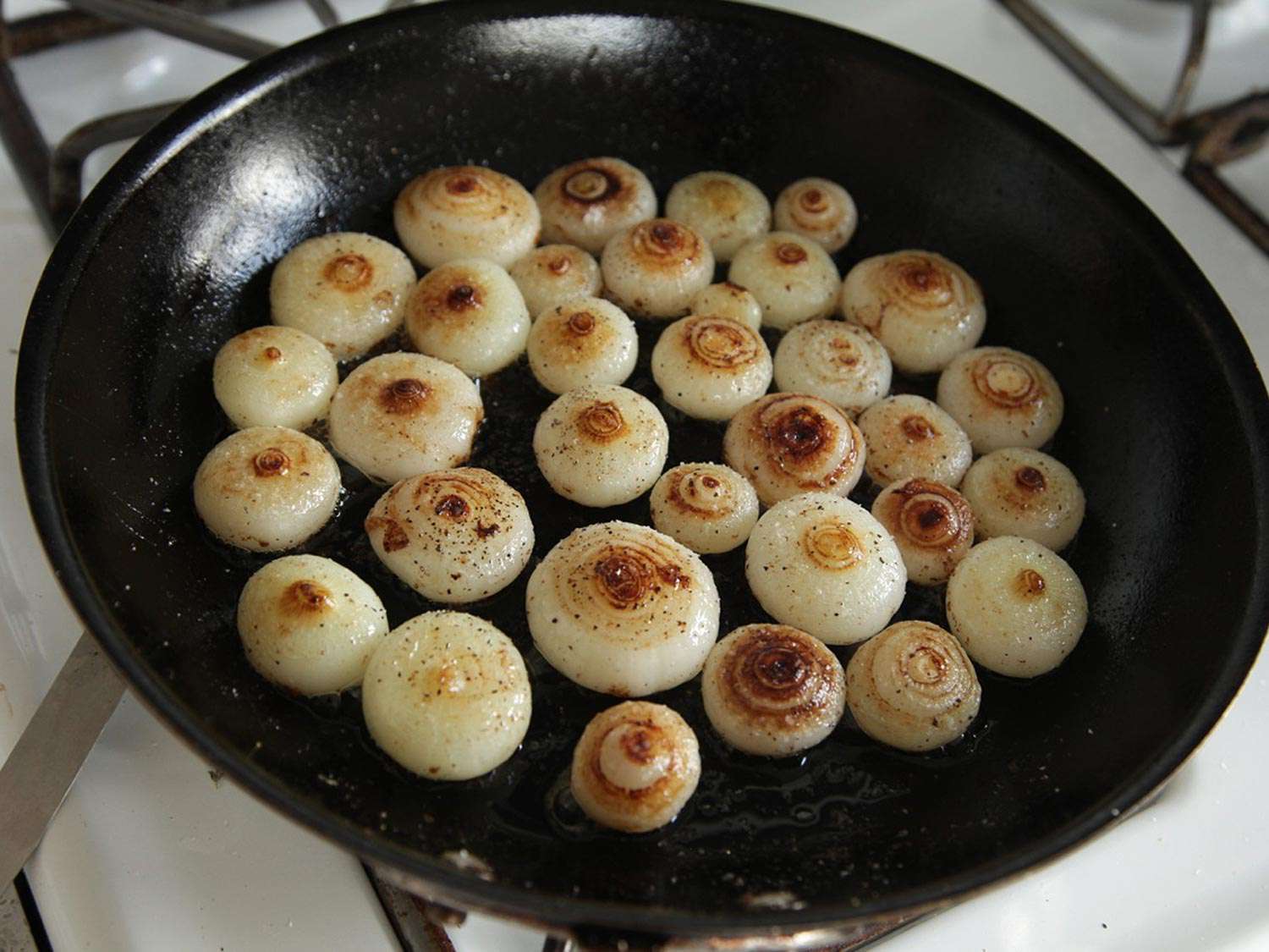 Cipollini onions in a cast iron skillet, just starting to caramelize.