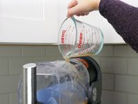 pouring liquid into the top of the ninja slushi