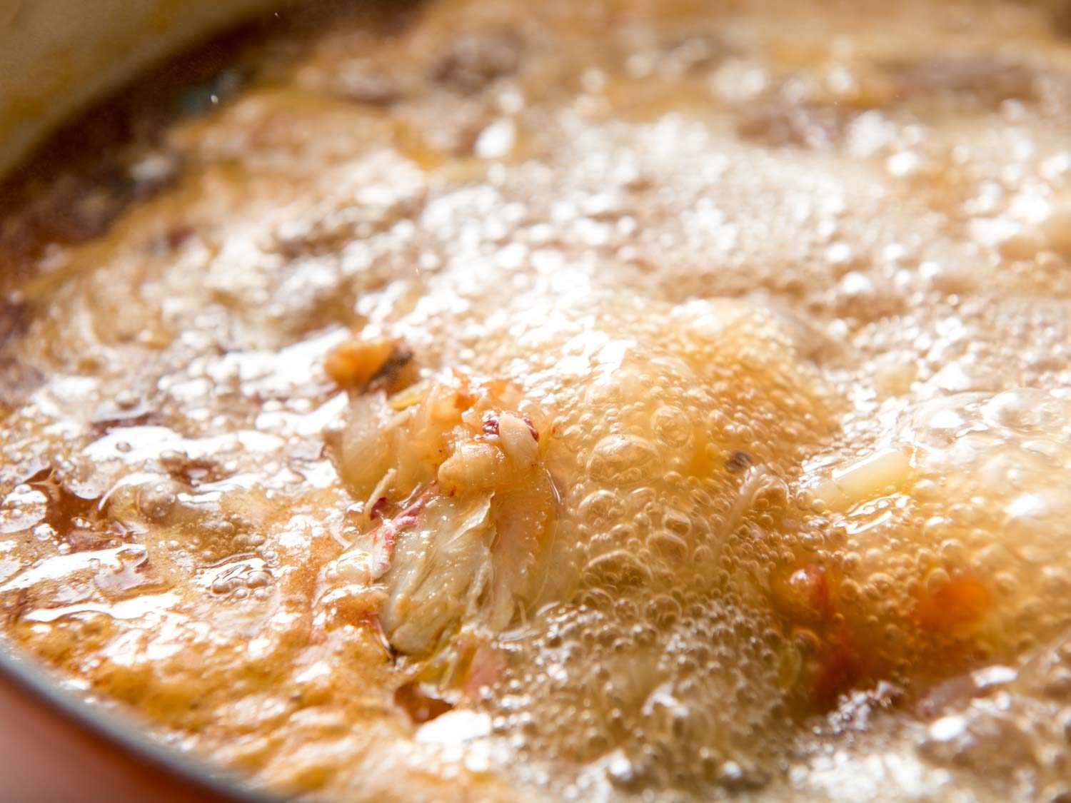 Close up view of vigorously boiling fish stock for bouillabaisse.