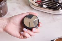 A person holding the Crema tamper.