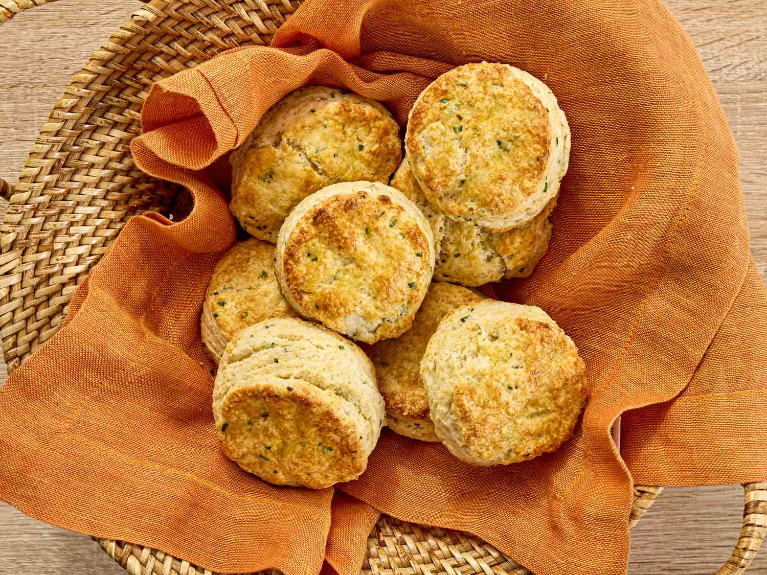 sour cream and chive biscuits in a basket with an orange napkin