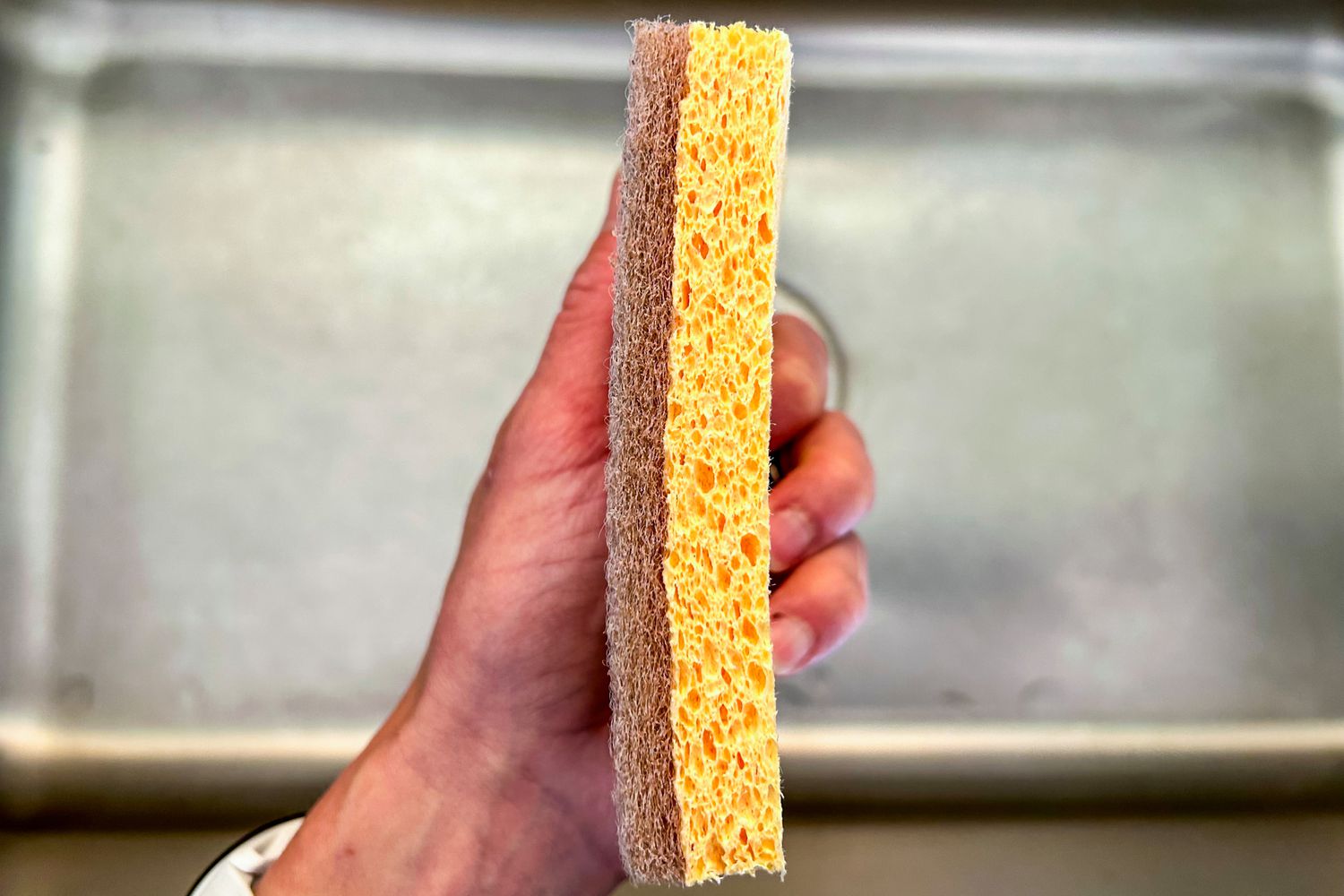 A side view of a textured dishwashing sponge from Public Goods