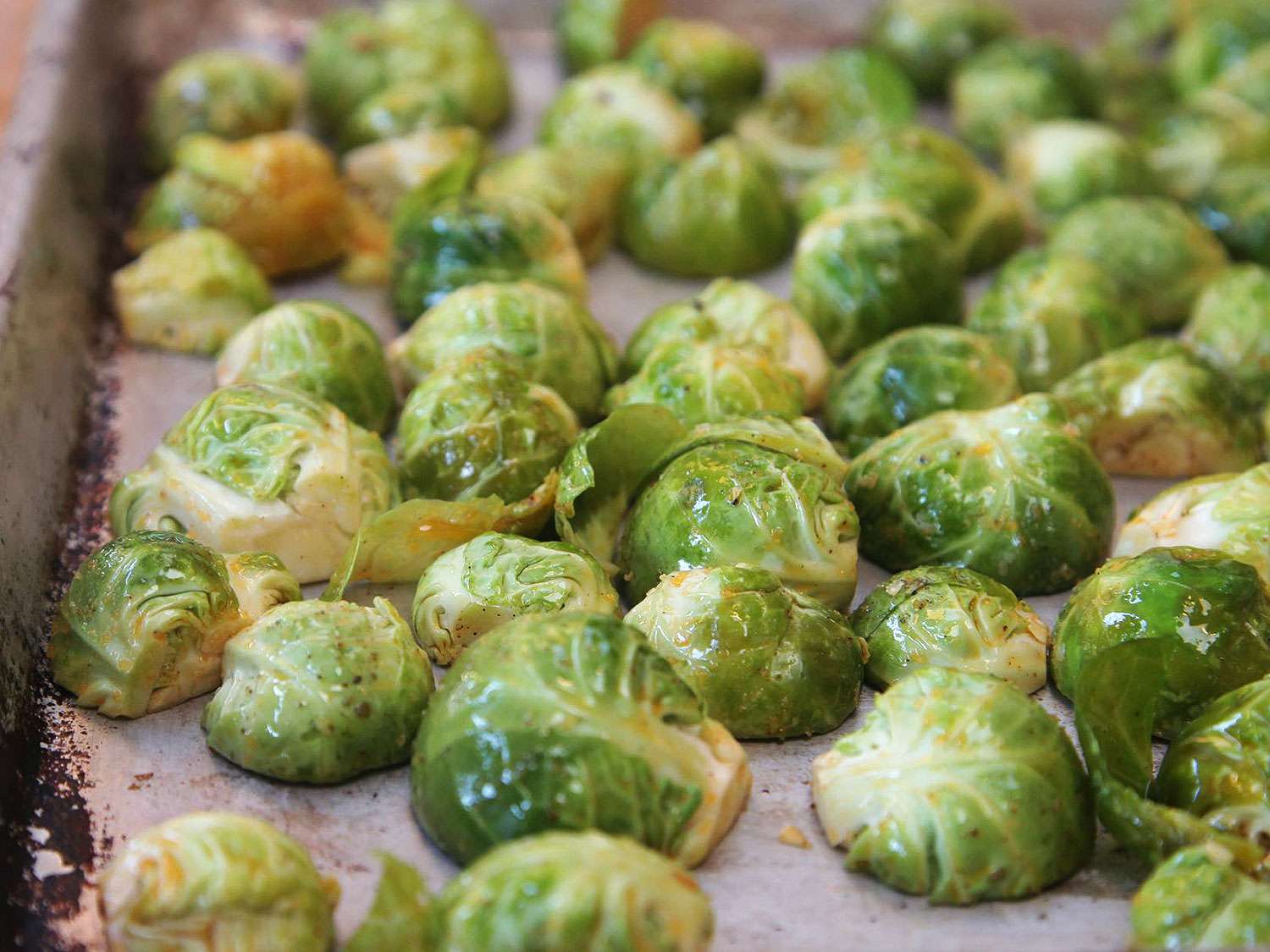 The Brussels sprouts are arranged on a sheet pan cut-side-down.