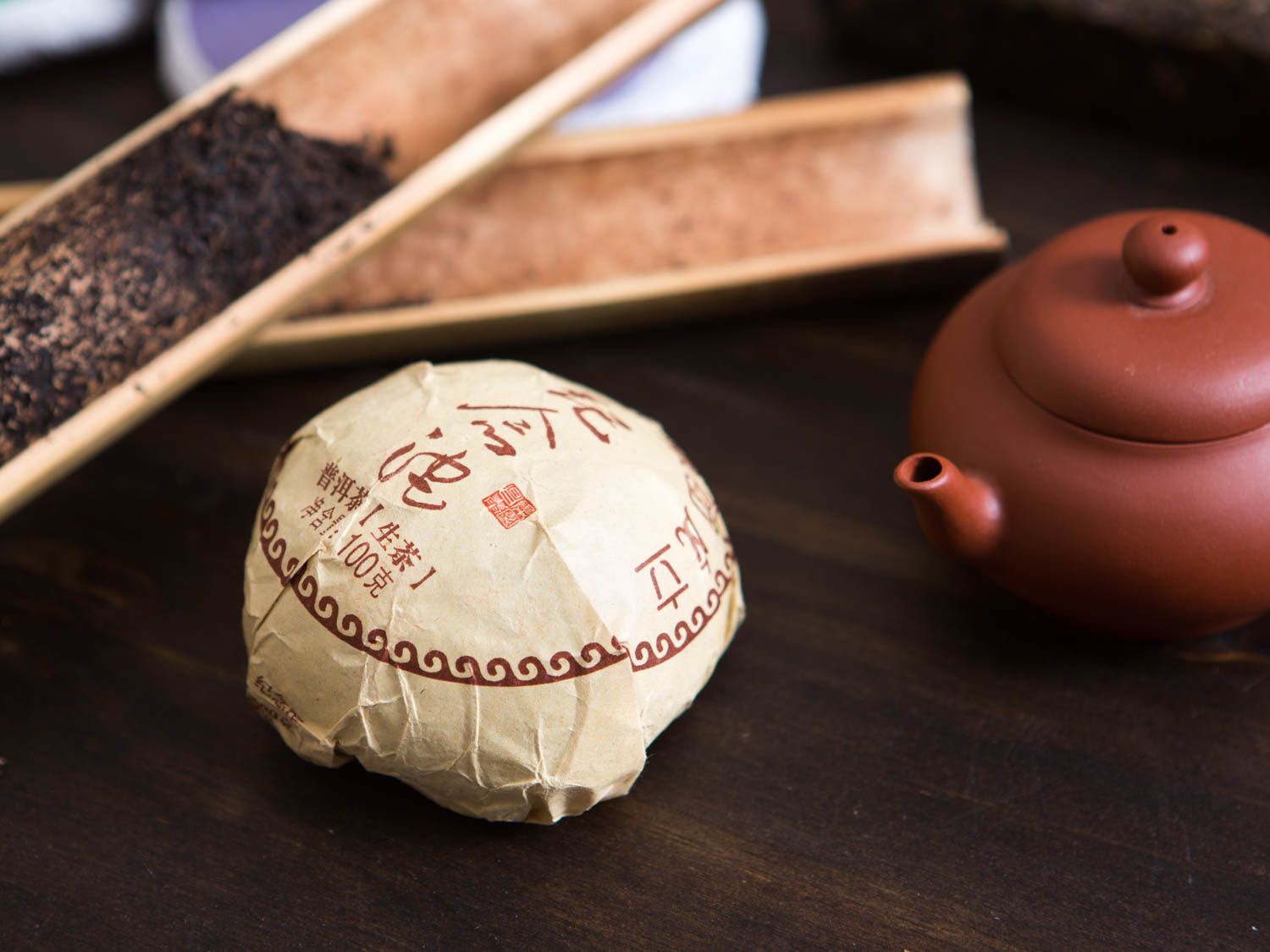 A package of tea next to a tea pot
