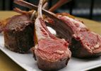 perfect slow-cooked lamb racks arranged standing up on platter