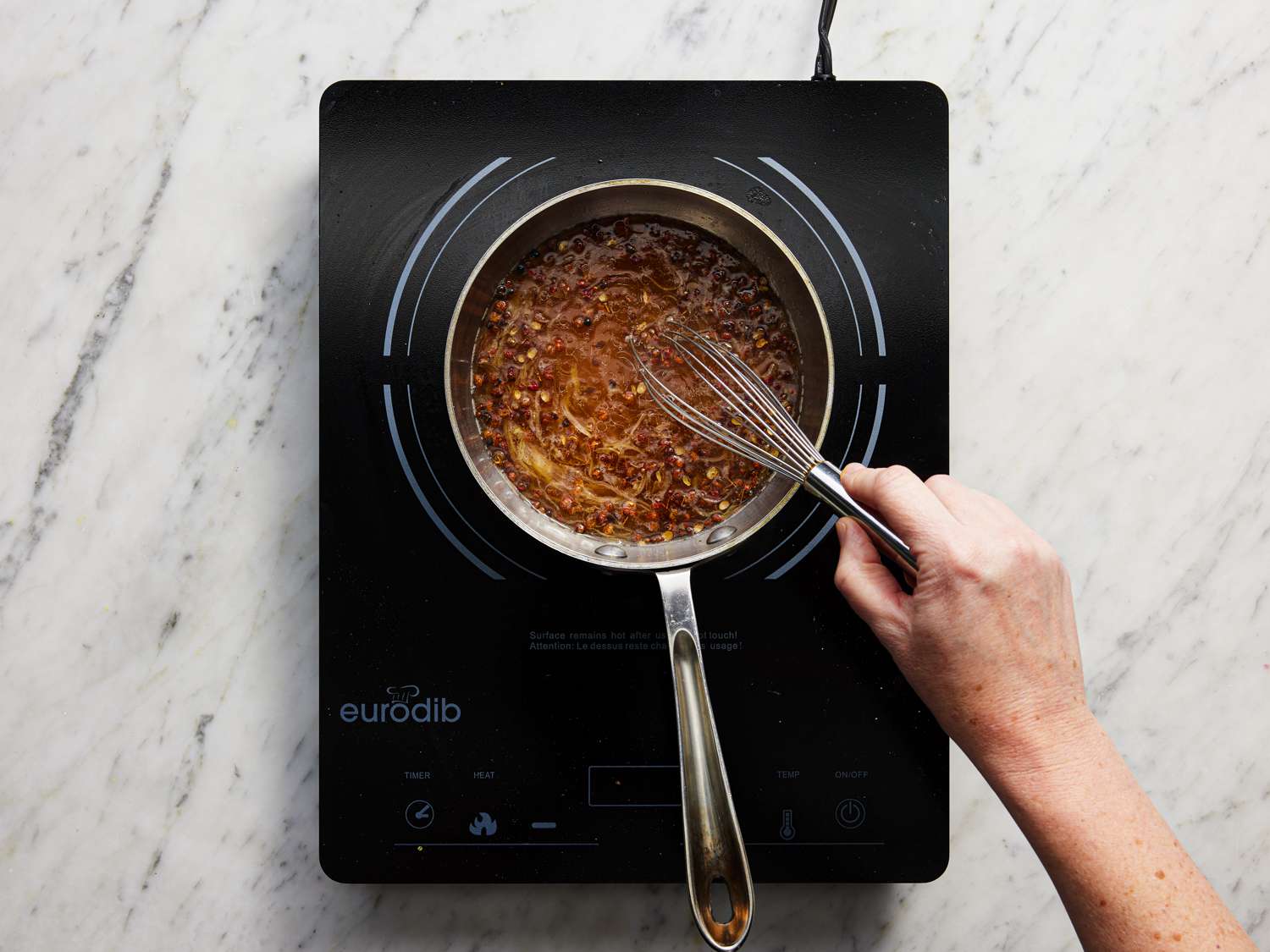 Whisking shallots and oil mixture together 