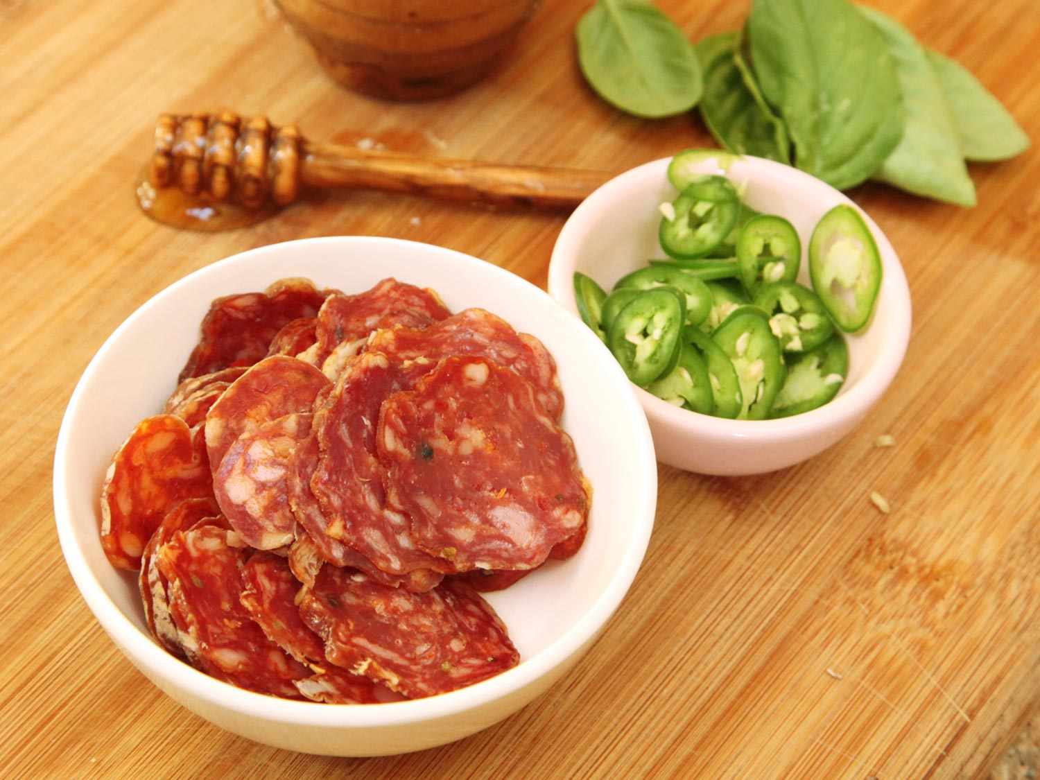 Sliced spicy dry salami, sliced fresh jalapeno pepper, basil leaves, and honey