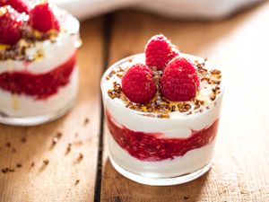 A glass of cranachan topped with fresh raspberries.