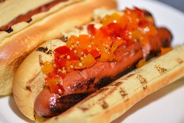 A grilled hot dog topped with three pepper relish.