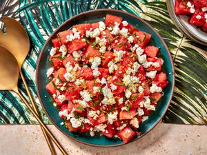 Watermelon, feta, and mint salad in a bowl on a colorful tropical print napkin.