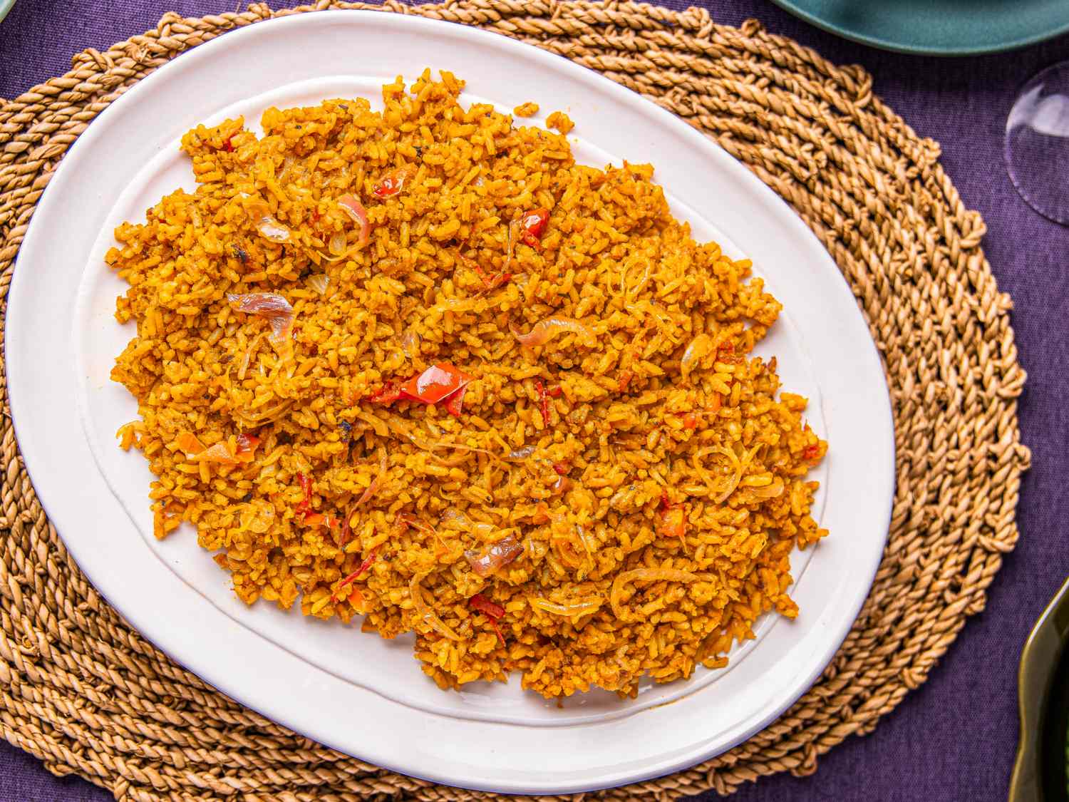 A plate of Nigerian Jollof rice served on a woven mat