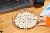 A hand holding marshmallows before being heated in the Magic Chef 1.1 Microwave