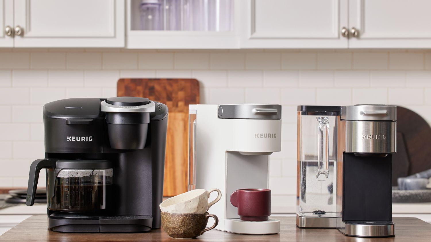 three keurigs on a stainless steel tabletops