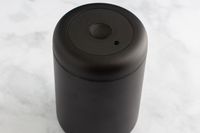 The Fellow Atmos Vacuum Coffee Canister sitting on a marbled surface