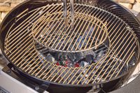 Tongs touching the Weber Performer Deluxe Charcoal Grill 22