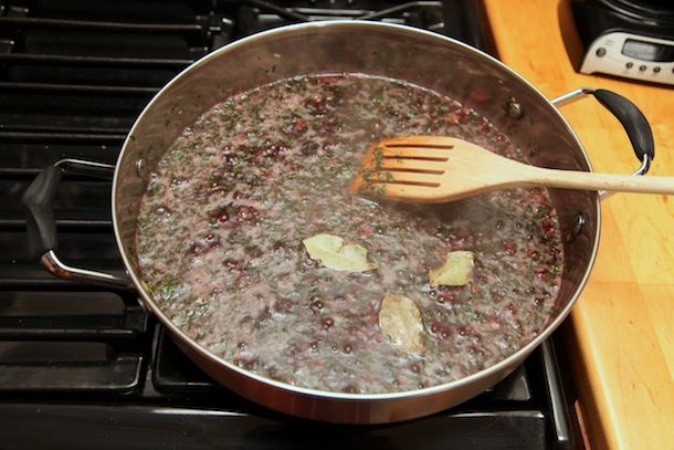 Red wine and bay leaves are added to the pan.