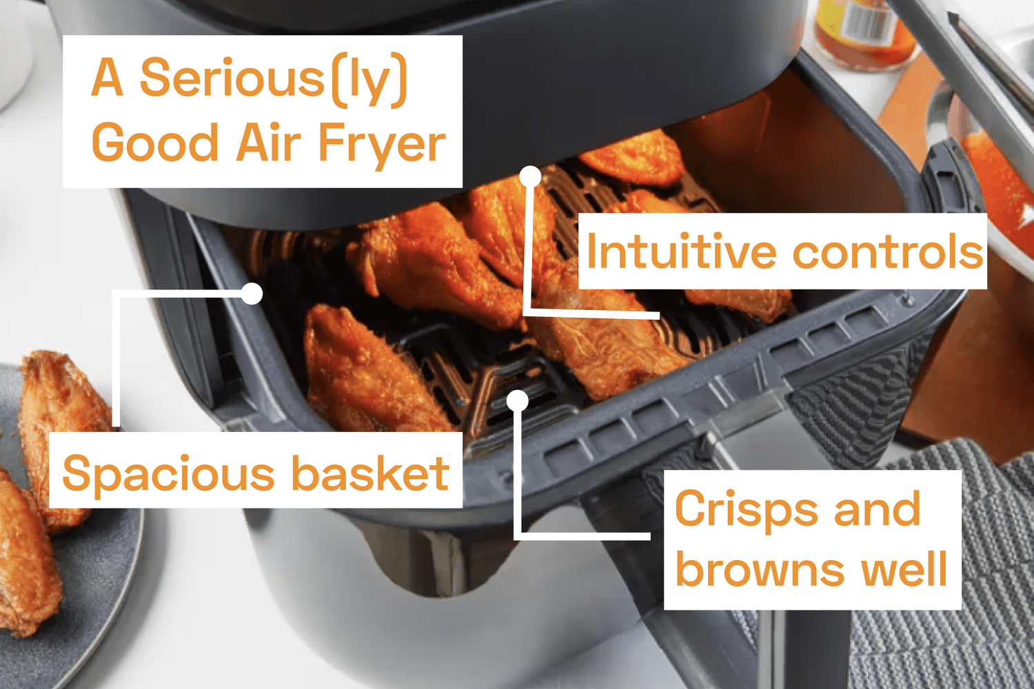 An air fryer basket partially pulled out and full of chicken wings.