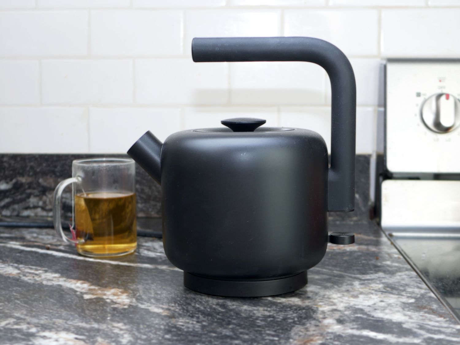 fellow clyde electric tea kettle with tea cup behind it