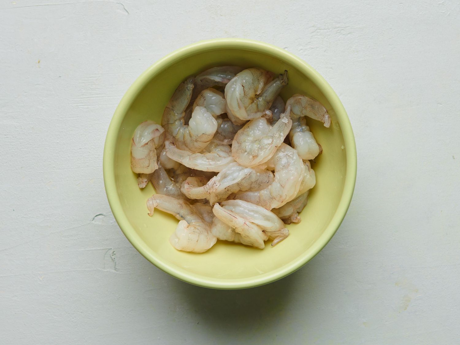  Shrimp, baking soda, 1 teaspoon of salt, and 1/4 cup of water mixed inside a small yellow bowl.