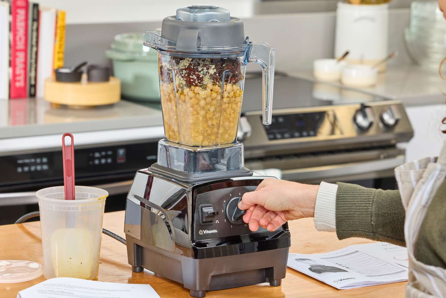 A hand turning a nob on the Vitamix E310 Explorian Blender