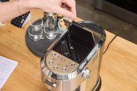 A person opens a door on the De'Longhi EC900M Dedica Maestro Espresso Machine